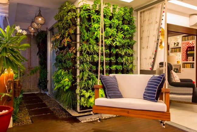 A cozy and vibrant balcony with greenery and a swing